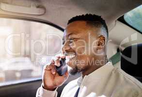 Black businessman travelling alone in a taxi while talking on a call using his wireless smartphone device in the morning on his way to work in the city