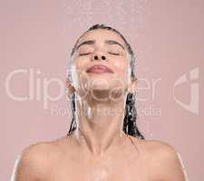Allow yourself to luxuriate. a young woman rinsing her hair against a studio background.