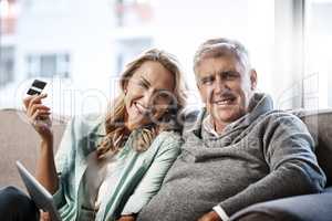 Convenience is the biggest perk about online shopping. Portrait of a mature couple using a digital tablet and credit card to do online shopping at home.