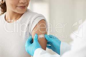 Youre officially vaccinated. an unrecognisable doctor applying a band-aid after injecting her patient during a consultation in the clinic.