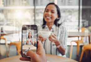 Close up of device screen while taking picture of beautiful young woman holding coffee cup and enjoying date in cafe. Man taking photo of his smiling girlfriend