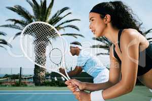 We got this. Shot of an attractive young woman standing and playing tennis with her teammate.