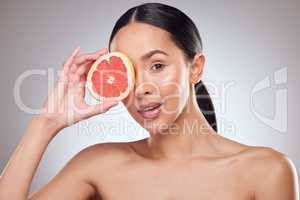 Maintain the integrity of your skin with organic ingredients. Studio portrait of a beautiful young woman posing with grapefruit against a grey background.