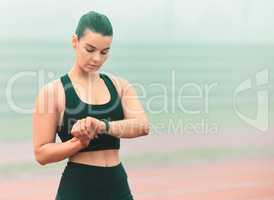 Lets see what times Im doing. an attractive young sportswoman checking her smartwatch while standing out on the track.