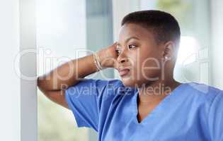 Every nurse was drawn to nursing. Shot of a female nurse looking stressed while standing in a hospital.