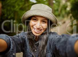 Selfies in nature. Cropped portrait of an attractive young woman taking selfies while hiking in the wilderness.