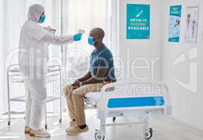 Medical doctor using thermometer to scan the temperature of a patient. African American patients having their temperature scanned. Doctor checking a patient temperature for covid symptoms