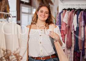 Its my favourite store. an attractive young woman standing in a clothing store during her shopping spree.