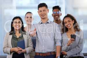 Appreciate all that you do for our team. Portrait of a young businessman reaching out to shake hands while surrounded by his team in a modern office.