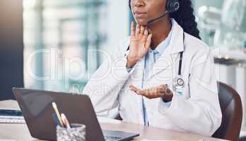 Closeup african american woman doctor using her laptop to do an online remote consult while sitting in her office in the hospital. Testing during the pandemic outbreak. Stop the spread of covid 19