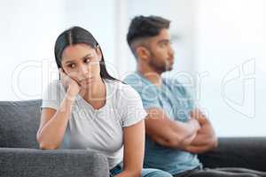 Im not happy at all. Shot of a young couple sitting on the sofa at home and ignoring each other after a fight.