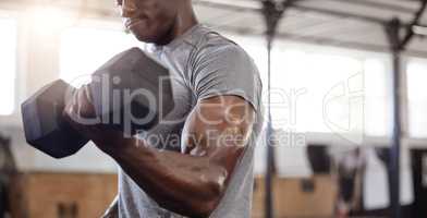 Unknown african american athlete lifting dumbbell during bicep curl arm workout in gym. Strong, fit, active black man training with weight in health and sports club. Weightlifting exercise routine