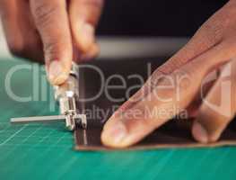 Its hands-on work. an unrecognizable male designer working with leather in his design studio.