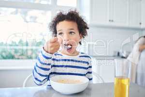 No-ones hungrier than a growing boy. Shot of an adorable little boy having breakfast at the kitchen table.