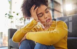 Young unhappy mixed race woman looking sad and thinking alone at home. One tired hispanic woman looking depressed and going through a breakup at home