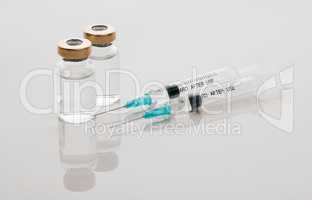 Weve got enough of the Covid vaccine to go around. Closeup shot of two vials of medicine and needles in an empty studio.