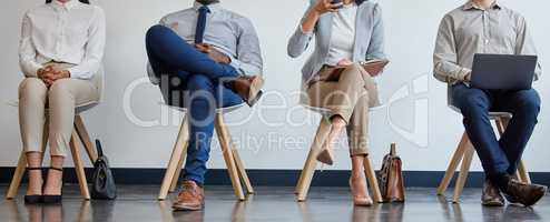 Were all just looking for new ventures. a group of businesspeople waiting in line at an office.