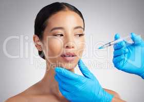 A gorgeous mixed race young woman getting botox filler. Hispanic model getting cosmetic surgery against a grey copyspace background