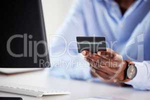 Closeup of one african american businessman spending money online with a credit card and computer in an office. Making purchase transaction with secure banking payment. Budgeting finance for bills and ecommerce shopping