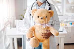 Dedicated to making my patients comfy. Shot pf a pediatrician holding a teddy bear in her office.