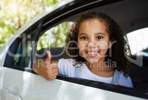 I approve of roadtrips. Cropped portrait of an adorable little girl giving thumbs up through the back window of a car.