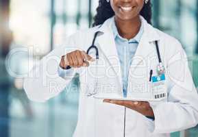 Closeup african american woman doctor using a digital tablet and interacting with copyspace in the hospital. Modern wireless technology is a vital resource. Health and safety in the field of medicine