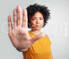 Im putting a stop to it myself. Studio shot of a woman gesturing to stop while standing against a grey background.