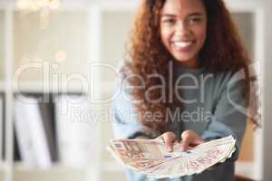 One happy young mixed race woman holding cash with two hands and feeling rich. Excited hispanic woman showing money after budgeting finances and saving. Planning for the future or winning a lottery