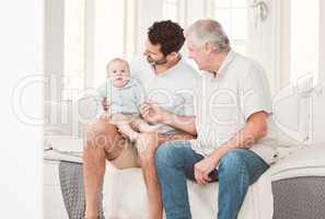 Finally meeting his grandchild. Shot of a grandfather spending time with his son and grandchild at home.