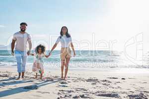 A walk in the sunshine. Full length shot of an affectionate young family of three taking a walk on the beach.