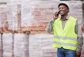 Shot caller on site. a handsome young construction worker making a phonecall while standing on a building site.