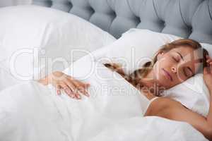 Sleep needs no explanation and is its own excuse. Shot of a woman asleep in bed at home.