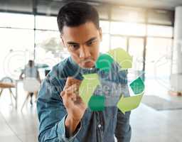 Young focused mixed race businessman drawing a recycle symbol on a glass window in an office at work. One serious hispanic businessperson designing a sign for awareness to recycling