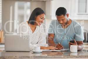 We definitely made some savings. Shot of a couple going over paperwork together at home.