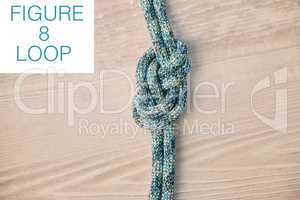 Above shot of hiking rope tied in a knot against a wooden background in studio. Figure 8 knot, A knot for every situation. Strong rope to secure safety while mountain climbing or doing extreme sports