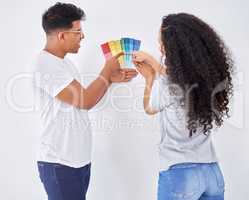 This is the perfect color for the walls. Shot of a young couple looking at color swatches while busy renovating a house.