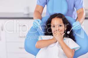 Ready for your tooth repair. Shot of a young girl looking scared while having dental work done on her teeth.