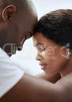 Closeup of a young african american married couple standing face to face with their foreheads touching together. Black man and woman in a loving relationship sharing intimate moment with eyes closed