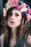 Goddess of the garden. Portrait of a beautiful young woman wearing a floral head wreath and holding shears.
