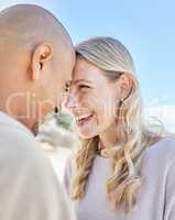 Intimate romantic couple bonding during a date. Mature loving interracial man and woman laughing and spending time together at the beach standing close to each other and smiling affectionately.