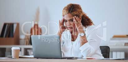 Young serious mixed race businesswoman looking stressed working on a laptop alone in an office at work. Hispanic woman unhappy while reading an email. Businessperson looking tired and worried
