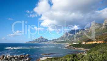 A beautiful sea landscape near a mountain with lush green plants growing outdoors in nature. Peaceful and scenic view of the ocean or beach with copy space on a summer afternoon