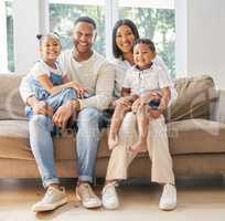 Family makes a person a human being. a young family happily bonding together on the sofa at home.