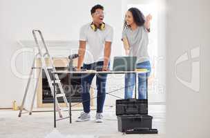 Renovating a house is a no brainer for people who like a challenge. Shot of a young couple using a laptop while busy renovating a house.