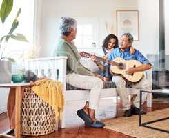 What should I play next. Shot of a grandfather playing guitar for his grandchild at home.