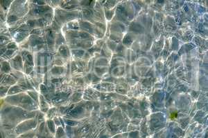 Clear beach water on a summer day with copy space. Top view of calm low tide sea ripples during spring. Closeup of the bright sun reflection shining off the shallow ocean useful as a background