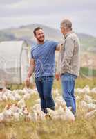 Weve had the best of cluck on our farm. Shot of two men working together on a poultry farm.