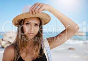 One beautiful young caucasian woman relaxing on the beach. Enjoying a summer vacation or holiday outdoors during summer. Taking time off and getting away from it all. Spending the day alone outside