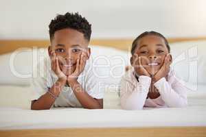 Brothers and sisters separated by distance joined by love. a brother and sister laying in bed at home.