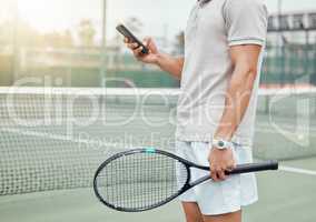 Unknown mixed race tennis player using cellphone to text during break in game on court. Hispanic fit athlete browsing internet and networking on phone after match. Active healthy man in sports club